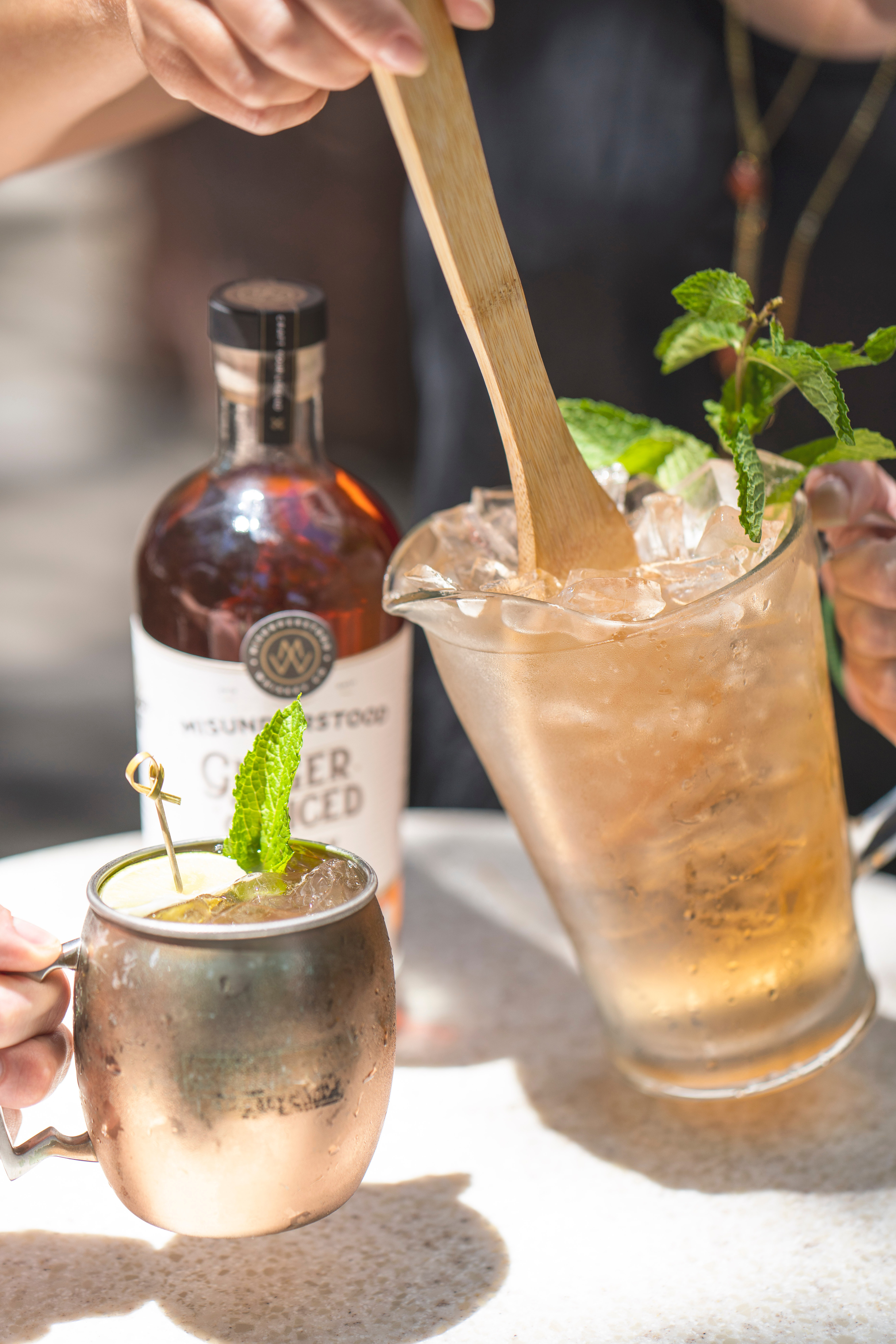 Moscow Mule in the copper mug beside a pitcher.